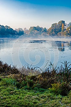 The lake is surrounded by autumn trees reflected in the mirror surface of the lake