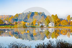 The lake is surrounded by autumn trees reflected in the mirror surface of the lake