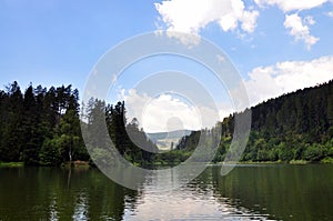 Jezero obklopené lesy v letním dni na Slovensku
