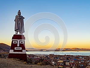 Lake Titicaca at sunset from Huajsapata Hill viewpoint with the monument to Manco Capac in foreground, Puno, Peru photo