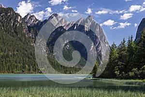 Lake Toblach with turquoise water and mountains of the Dolomite Alps during sunny summer day, South Tyrol Italy photo