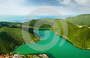 Lake with turquoise water in the green mountains with sea view