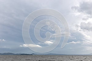 Lake with very white clouds over an island