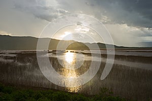 Lake view floating house boat of fishing village at sunset with cloud, rain and storm.