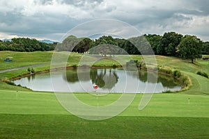 Lake of water in the middle of a green golf course