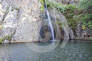 Lake and waterfall on the river beach of Pego set amongst the mountains of the Portuguese village of Penha Garcia, PR3 circuit