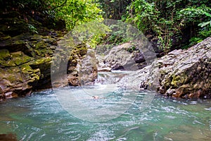 A lake with a woman swimming in the tropical forest