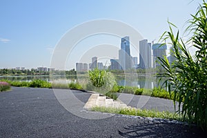 Lakeside blacktopped path and stone stairway in morning with modern city across lake photo