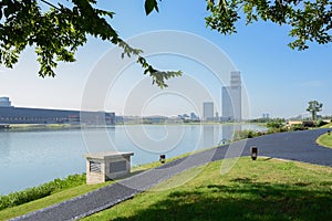 Lakeside blacktopped promenade on grassy lawn in sunny summer morning photo