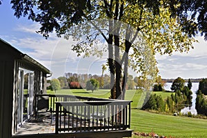 A lakeside cottage with the view of the lake and a walkout deck