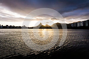 Lakeside view of lake during sunset, almost dark.=