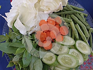 Lalapan or fresh raw vegetables basket. eaten with chili sauce as a complementary food. authentic indonesian food