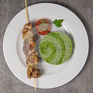 Lamb brochette marinated in spices, green semolina