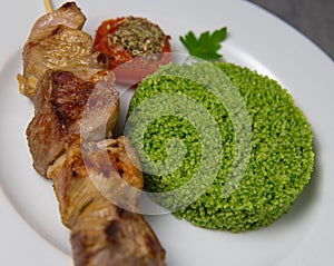 Lamb brochette marinated in spices, green semolina