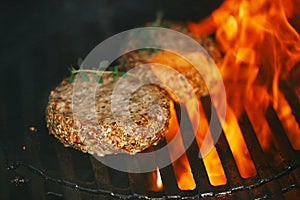 Lamb burgers spiced by lamb rub on bbq grill with flame photo