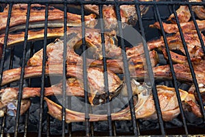Lamb chops cutlets grilling on barbecue rack on charcoals at picnic cookout outdoor. Delicious meat dish for carnivore or keto