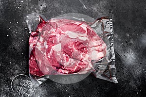 Lamb meat raw pack, on black dark stone table background, top view flat lay, with copy space for text
