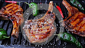 Lamb pork chops on grill sprinkle with salt and spices. Loin on ribs. Slow motion