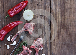 Lamb raw barbecue ribs, paprika and onions on dark rough boards, top view with space