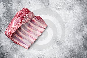 Lamb ribs cooking. Raw rack of lamb meat, on gray stone table background, top view flat lay, with copy space for text