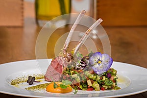 Lamb ribs with vegetables salad and edible flowers