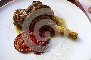 Lamb shank and grilled tomato for lunch