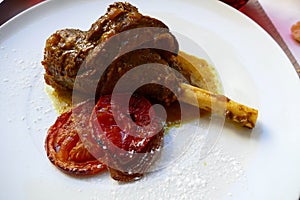 Lamb shank and grilled tomato for lunch