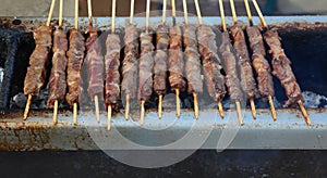 lamb skewers while cooking called ARROSTICINI in Italian