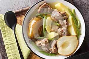 Lamb stew with pears, potatoes, green beans in a spicy sauce close-up in a bowl. horizontal top view