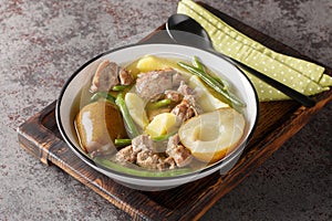 Lamb stew with pears, potatoes, green beans in a spicy sauce close-up in a bowl. horizontal