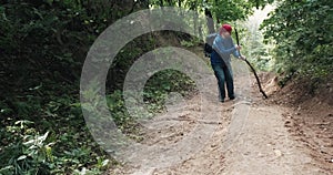 Lame hiker walks up a steep slope in the forest a person has a knee injury