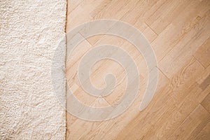 Laminate parquete floor with beige soft carpet photo