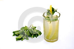 The lamon  jiuce in the glass with green leaves for mint
