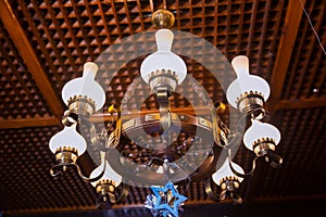 The lamp in the beautiful room . Chandelier ceiling lights . luxury expensive chandelier hanging under ceiling in palace.