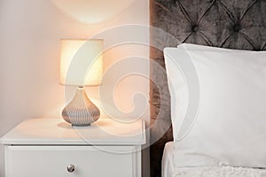 Lamp on bedside table in modern room