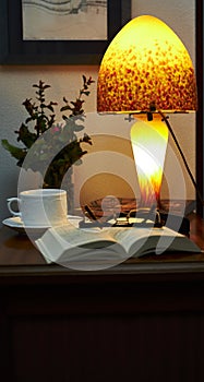 Lamp, book and glasses on a wooden table
