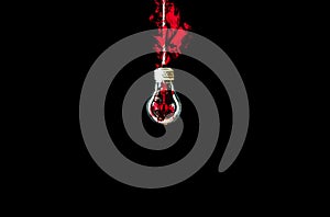Lamp bulb hanging on the rope. Red fire inside. New idea concept. Isolated on black background