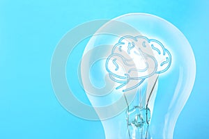 Lamp bulb with human brain inside on blue background, space for text. Idea generation