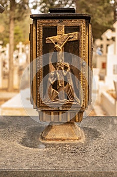 Lamp with the crucifix on the door in a graveyard