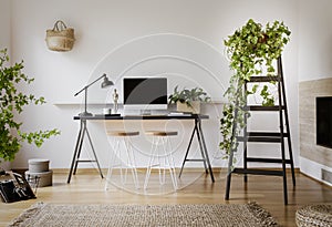 Lamp and desktop computer on black desk in workspace interior wi