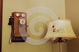 Lamp with Flower-patterned Shade next to Vintage Retro Antique Landline Wall Phone