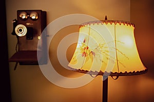 Lamp with Flower-patterned Shade next to Vintage Retro Antique Landline Wall Phone