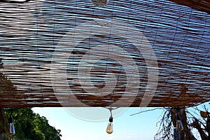 Lamp hanging from a bamboo made outdoor ceiling