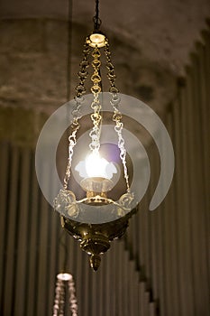 A lamp hanging on an iron chain on a blurred background