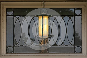 Lamp hanging outside a leaded glass transom window