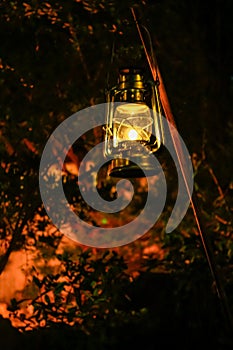 A lamp hanging in the rural, public park in the dark. Close-up of a lamp with black background.