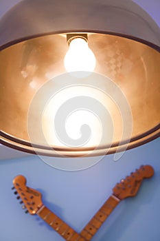 Lamp with lit bulb and the guitar masts. photo