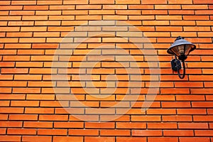Lamp on orange brick wall