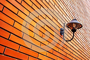 Lamp on orange brick wall