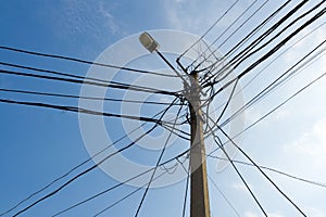 Lamp pole and cross of tangled electric wires photo